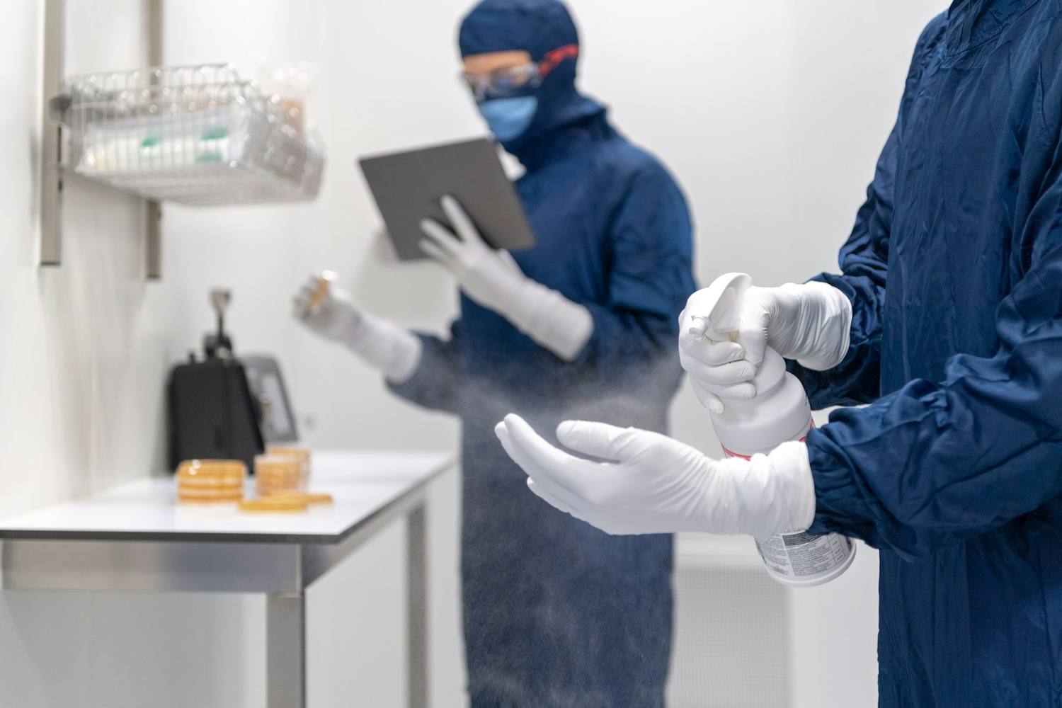 Technicians in cleanroom garments handling electronic assemblies